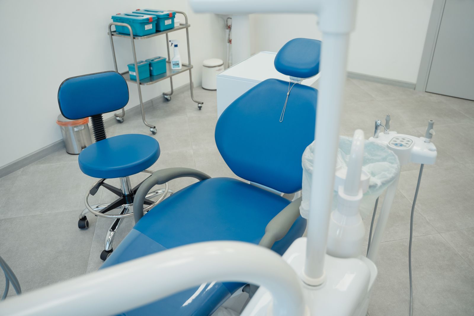 Bright treatment room with a blue dental chair